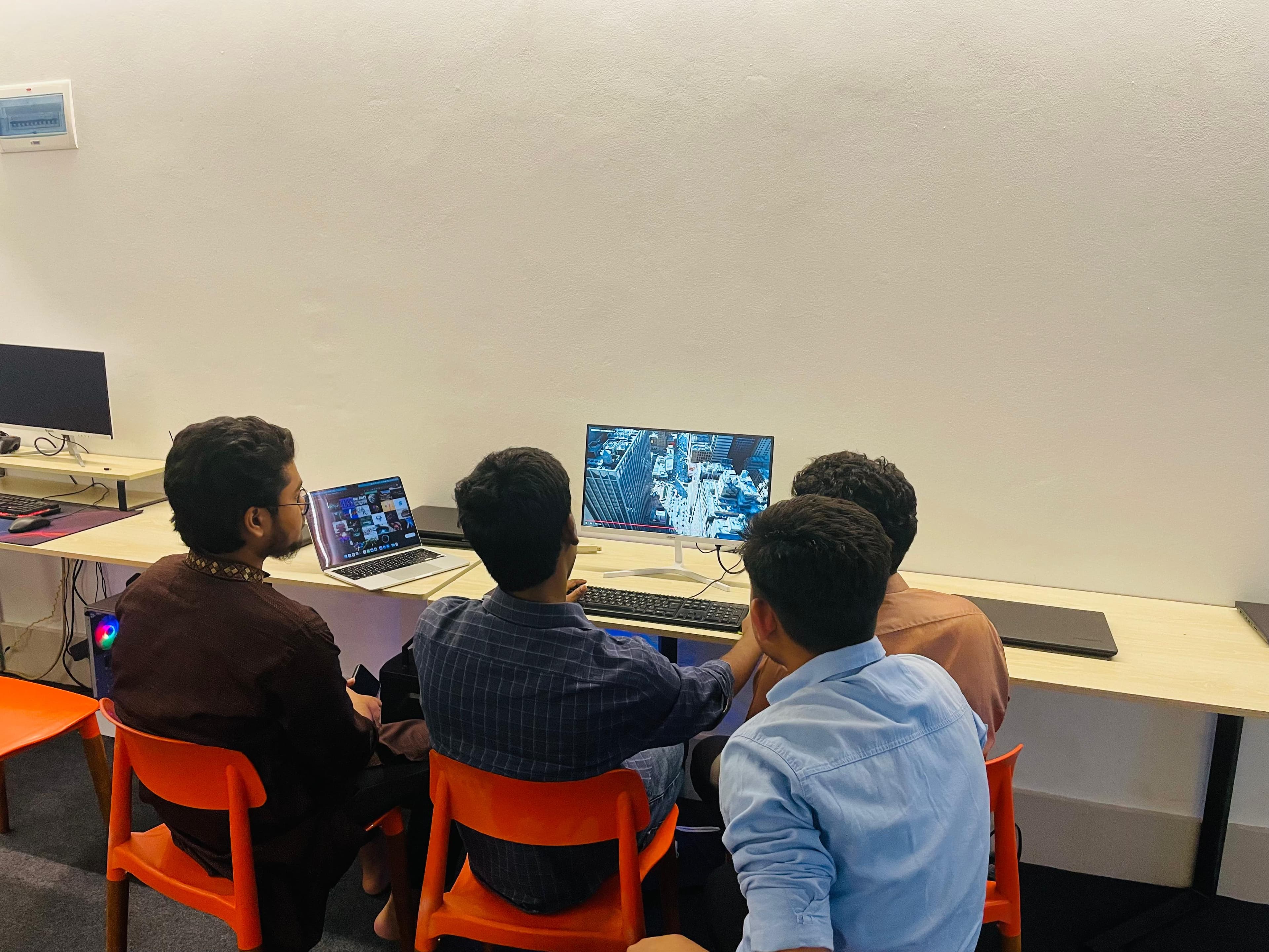 Students learning digital skills around a computer at Witen Academy